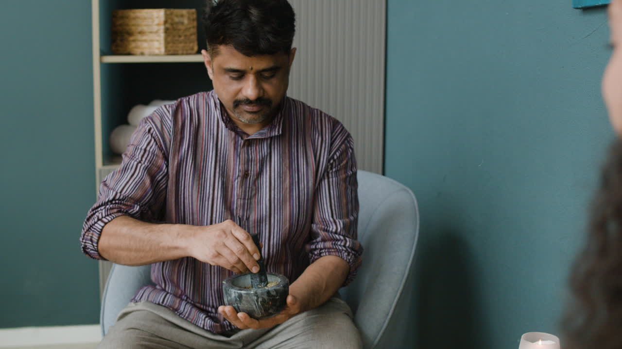 Man Preparing Herbal Medicine with Mortar and Pestle