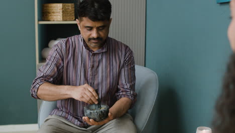 man preparing herbal medicine with mortar and pestle