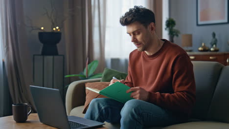 manager talking video conference looking laptop web camera on home couch.