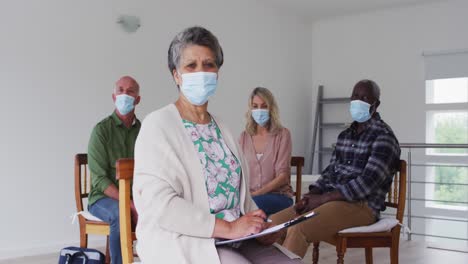 dos parejas mayores diversas sentadas en círculo teniendo una conversación de terapia en casa mirando a la cámara