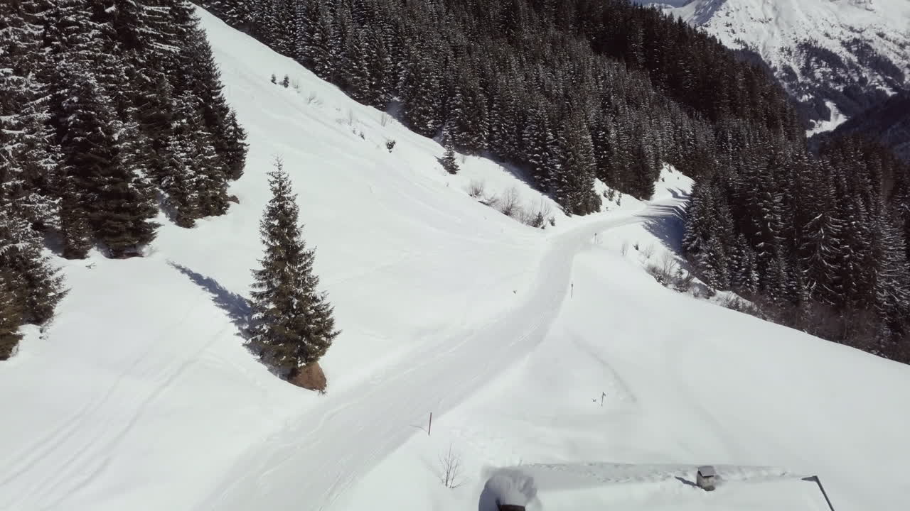Avusturya Alpleri'ndeki Kleinwalsertal kayak bölgesinde karlı manzara ve patikanın havadan drone çekimi.