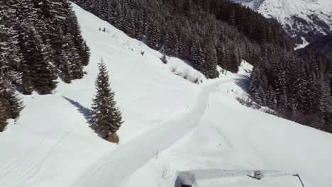 aerial drone shot of snowy landscape, pathway in skiing area of kleinwalsertal in the alps, austria