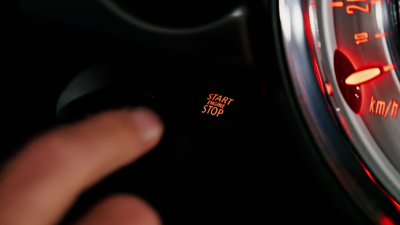 Close up of a man pressing the Start Stop engine on a car and taking the key out