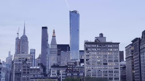 an iconic view of manhattan's skyline at twilight, featuring famous skyscrapers and the serene atmosphere of the city as day transitions to night