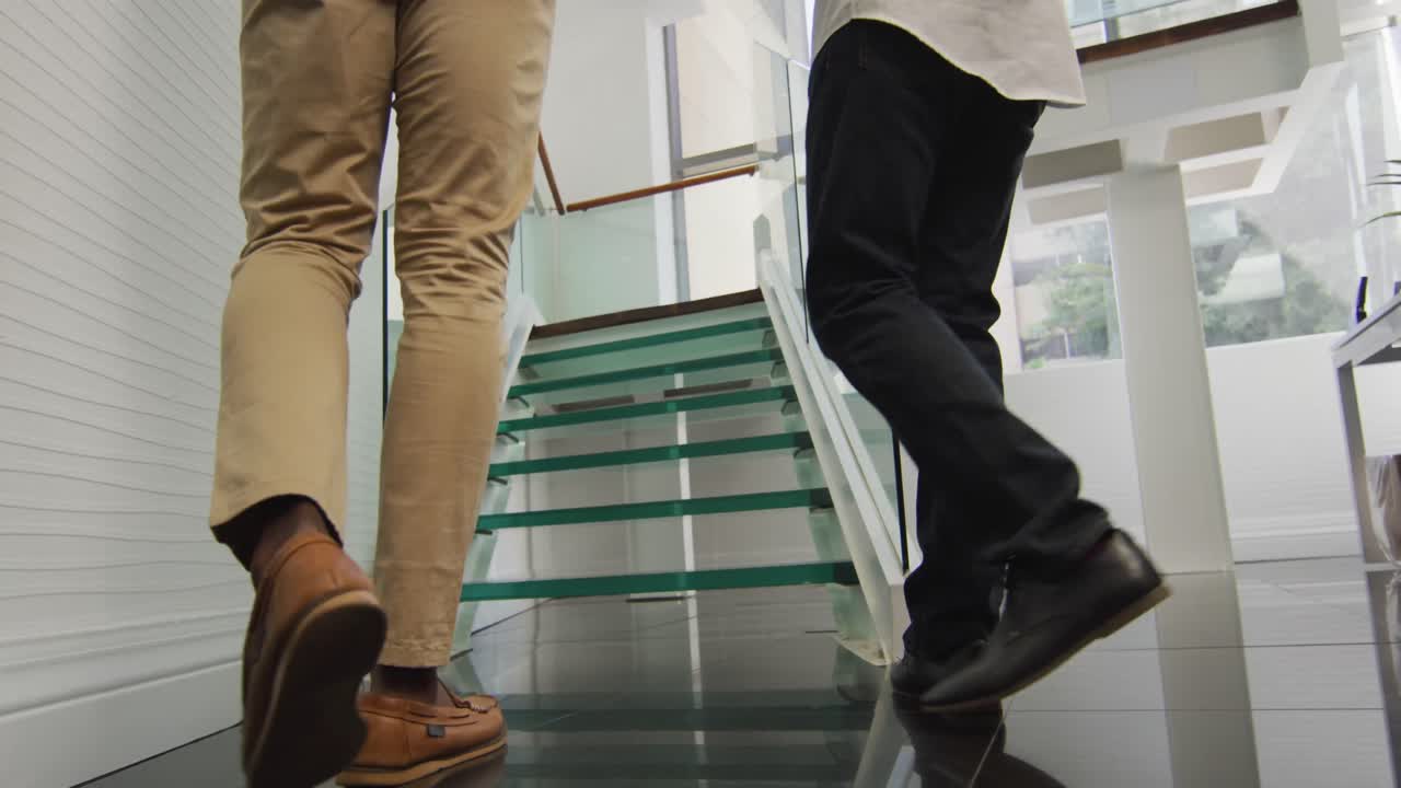 다양한 사업가들이 문서를 가지고 걸어서 창의적인 사무실에서 이야기하고 있습니다.