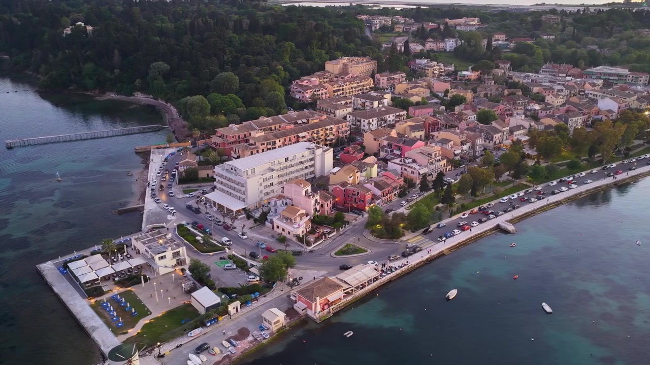 Upea dronelento Garitsan lahden yllä Korfulla esitellen historiallisen Anemomilos-tuulimyllyn, ylellisiä rannalla sijaitsevia hotelleja ja kirkkaan, tyynen Joonianmeren.