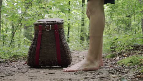 Close-up-of-mushroom-basket,-man-walks-bare-feet-and-puts-Chanterelles-mushrooms-inside-then-walks-away,-static,-day