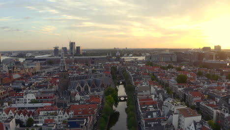 amsterdam rising drone shot over the oude church and basilica of saint nicholas at sunrise
