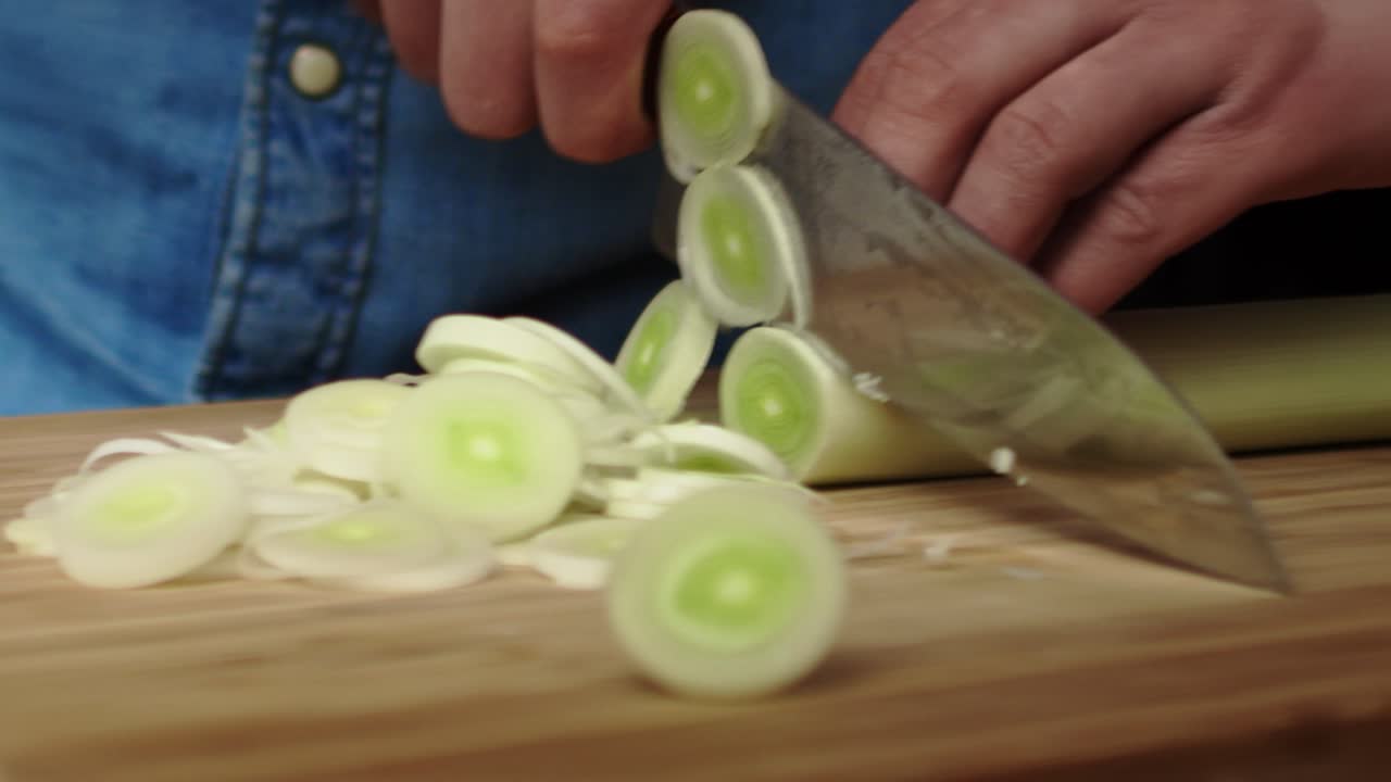 Tracking right video of slicing leek in the kitchen