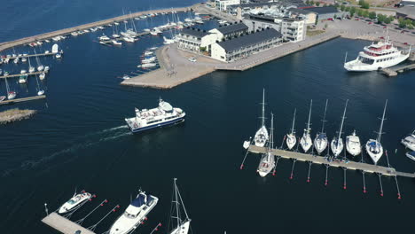 Vista-Aérea-De-Drones-De-Un-Pequeño-Puerto-De-La-Ciudad-Escandinava-Con-Un-Barco-De-Transporte-De-Pasajeros-Que-Ingresa-Al-Puerto-Al-Final-De-Un-Viaje-Para-Turistas-Que-Viajan-A-Través-Del-Océano-Sueco-En-Aguas-Tranquilas