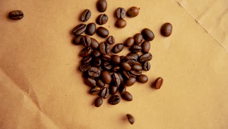 coffee beans drop from above on old paper slow motion vintage look