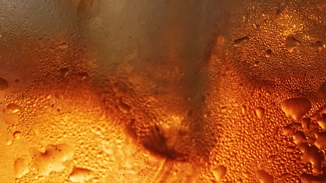 primer plano de vidrio mirando a través de la condensación como cubos de hielo girando alrededor