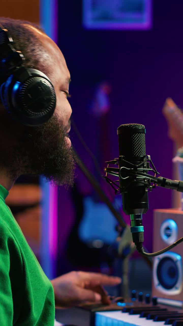 Uomo afroamericano felice che canta e produce musica in studio