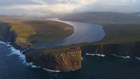 very far circular drone footage of the leitisvatn lake, aka the floating lake, on the vagar island in the faroe islands