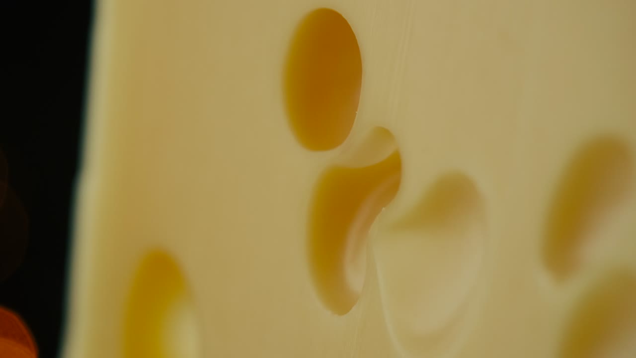 중간 단단한 치즈 머리 에담 과다 파르메잔을 나무판 위에 어 넣고, 견과류와 포도를 접시 위에 회전시니다.