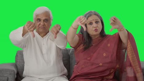 una vieja pareja india enojada mostrando los pulgares hacia abajo pantalla verde