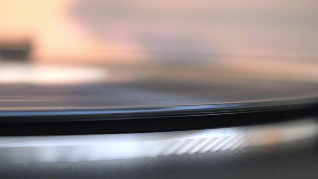 레코드가 레코드 플레이어에서 회전하기 시작하고 레코드 암이 비닐에 앉아 클로즈업