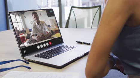 Mujer-Afroamericana-Usando-Una-Computadora-Portátil-Para-Videollamadas,-Con-Un-Colega-De-Negocios-En-La-Pantalla