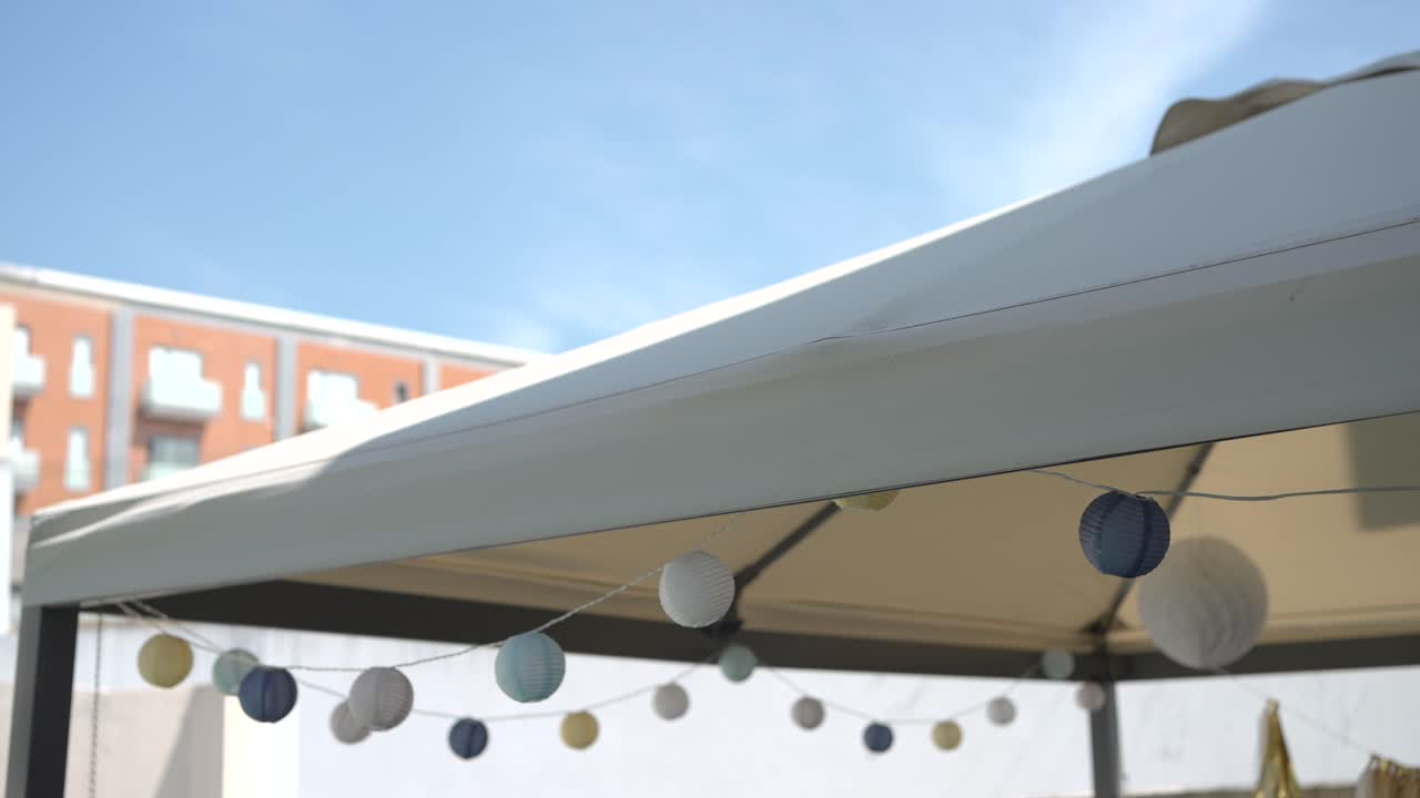 Outdoor canopy with decorative string lights under a clear sky, creating a festive ambiance