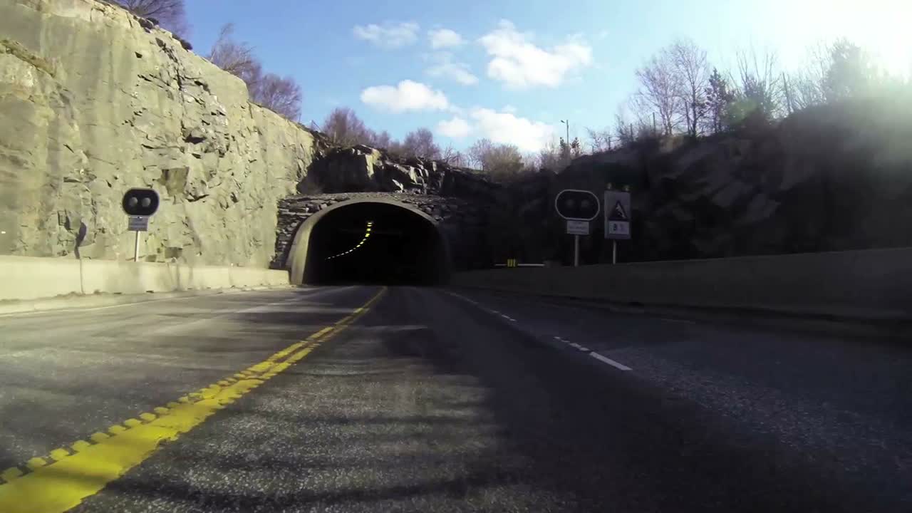 tiro pov de un automóvil que viaja a alta velocidad a través de un túnel a través de una montaña 1