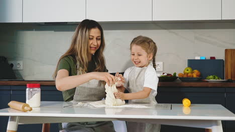 mother and daughter prepare dough in kitche