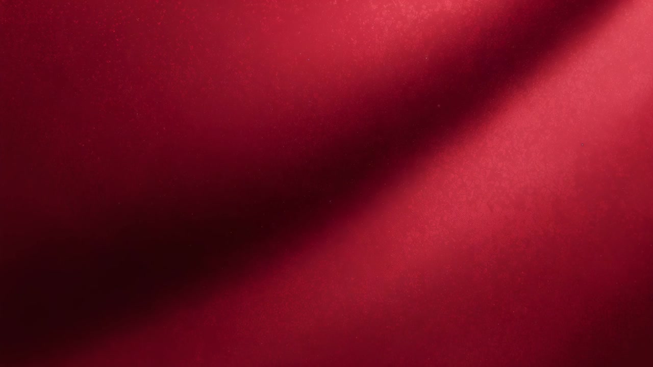 Immagine ravvicinata di un tessuto rosso che forma una piega curva dopo un leggero spostamento della messa a fuoco in una stanza, con un punto luce