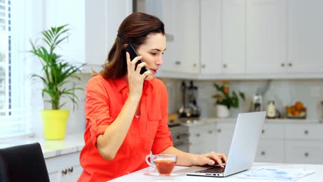 woman using laptop in kitchen 4k