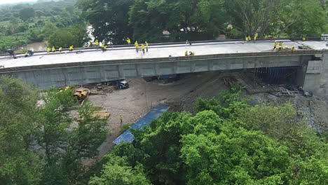 amazing reversal drone shot over construction workers building a bridge in a forest area