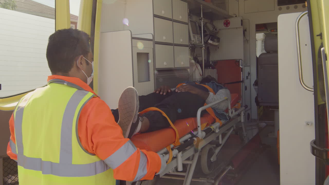 구급차에서 미국 환자와 거니를 꺼내는 남성 구급대 원