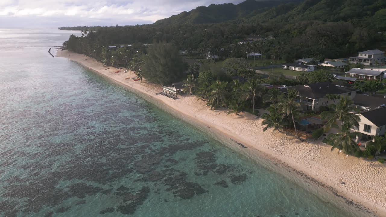 Aerial angled static of peaceful sandy beach and tropical coastline, Cook Islands Rarotonga
