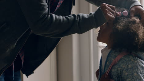 father preparing daughter for school putting cute bow in little girls hair enjoying caring for child