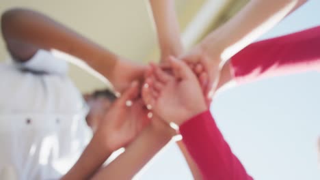 video of diverse boys putting hands on each other in front of school