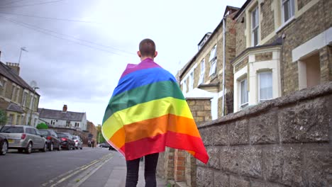 caminando con la bandera del orgullo en los hombros