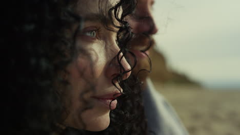 hispanic woman face looking blowing wind. couple enjoying sea beach landscape.