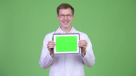 happy man doctor showing chroma key green screen digital tablet