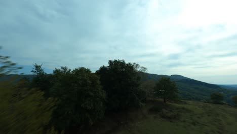 Renndrohne-FPV-Fliegt-Auf-Grünen-Feldern-Der-Landschaft-Von-Uchon,-Morvan-In-Frankreich