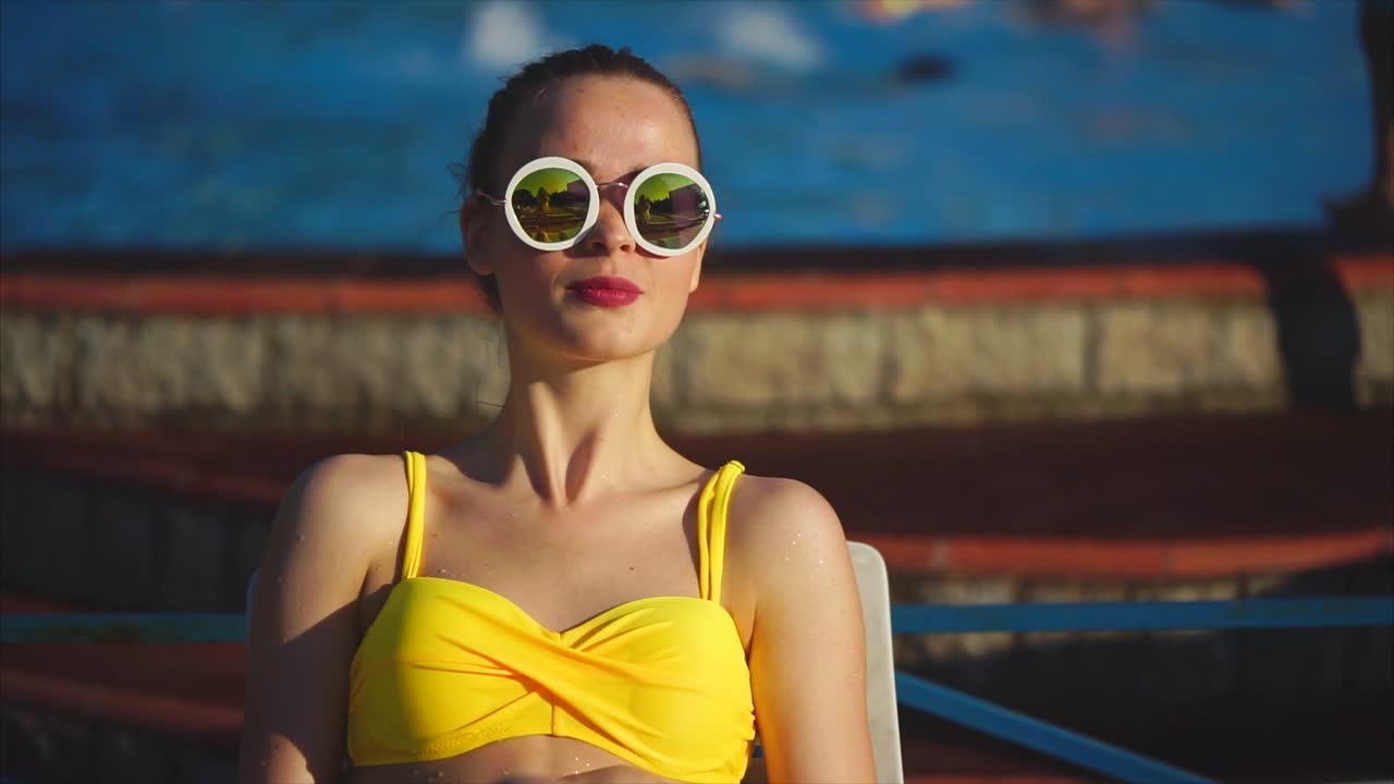 женщина отдыхает у бассейна.