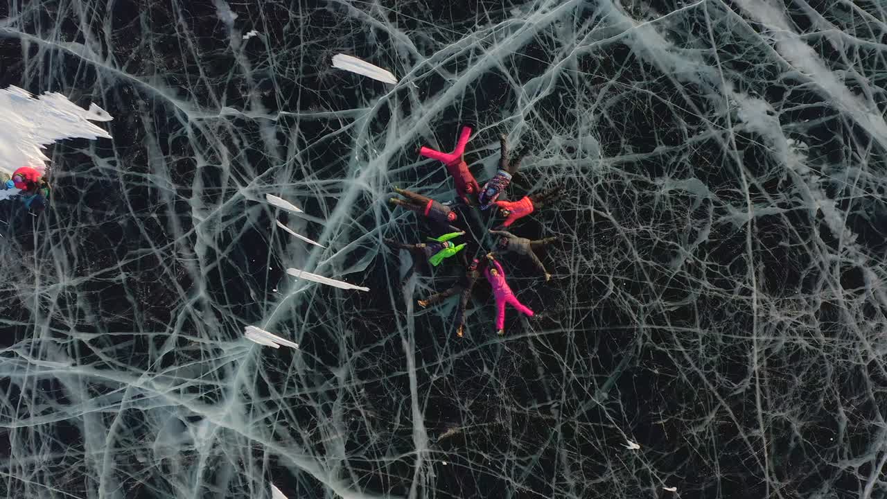 los turistas se acuestan en el hielo del lago congelado de baikal y realizan movimientos sincronizados.