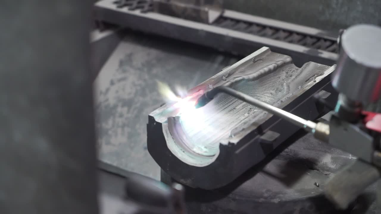 Close-up of precision die welding with a torch, industrial craftsmanship, bright flame on metal
