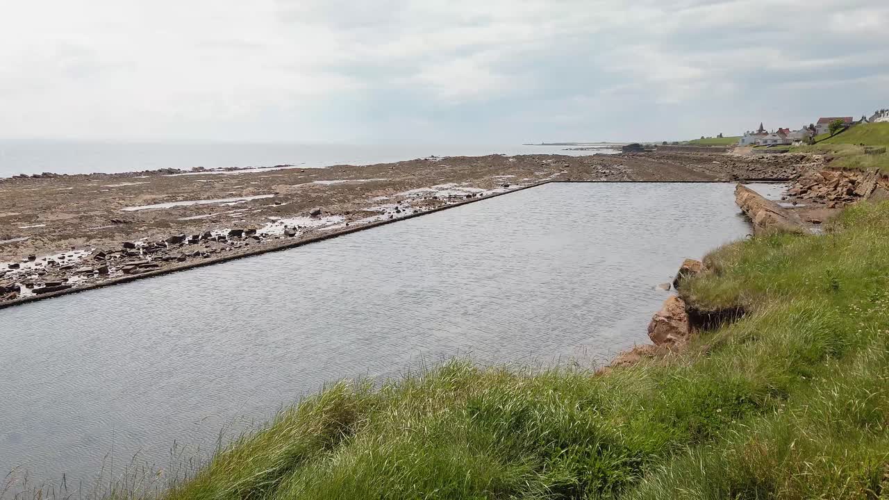 Gammelt sjøfylt svømmebasseng ved lavvann i St Monans, Fife, Skottland