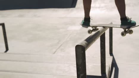 low section of caucasian man riding and jumping on skateboard on sunny day