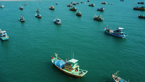 many fishing boats moored on coastline with ke ga lighthouse in horizon