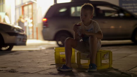 abandoned child having snack sitting in the street