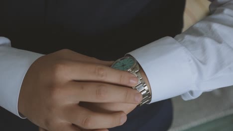 groom's preparing his watch close up