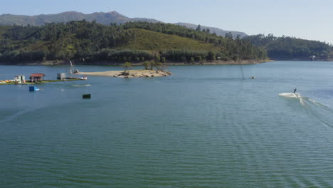 Water-Skiing-On-The-Calm-Lake-Water-In-Teleski-Water-Park-In-Vieira-Do-Minho,-Portugal-On-A-Summer-Day---aerial-drone