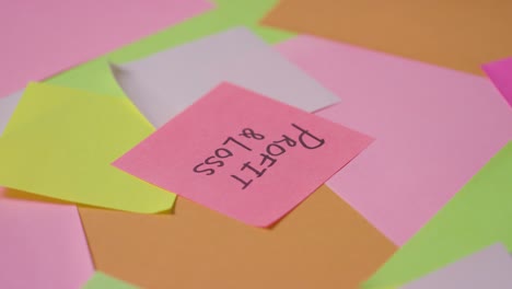 business concept of revolving sticky notes with profit and loss written on top note 1