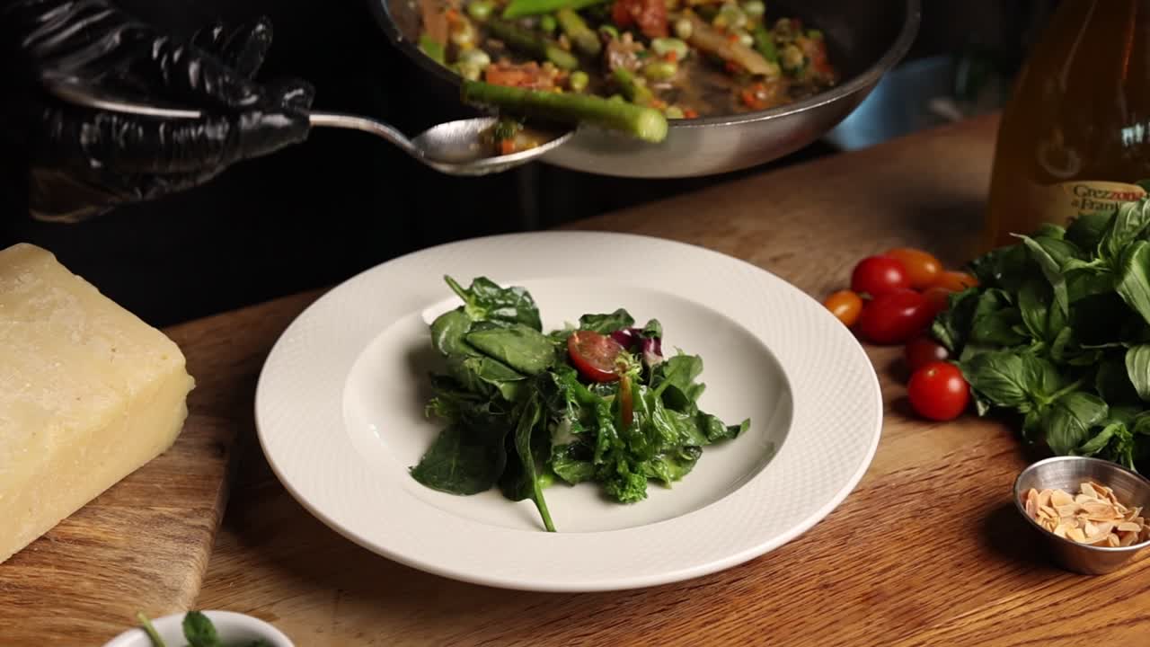 Chef che Impiattano Insalata Fresca di Asparagi e Verdure in una Cucina di Ristorante