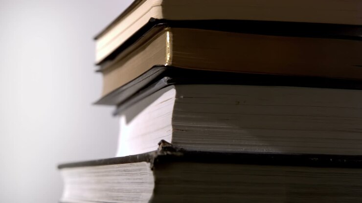 Pesanti libri neri che cadono su una superficie bianca