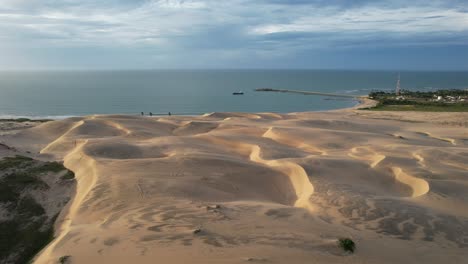 beautiful take with drone leaving the middle of the dunes towards the sea, northeast of brazil, magic light of the sunset