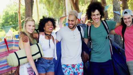 friends standing together with arm around in park 4k